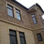 Facing the facade of a house with brick and stone: tiles and thermal panels