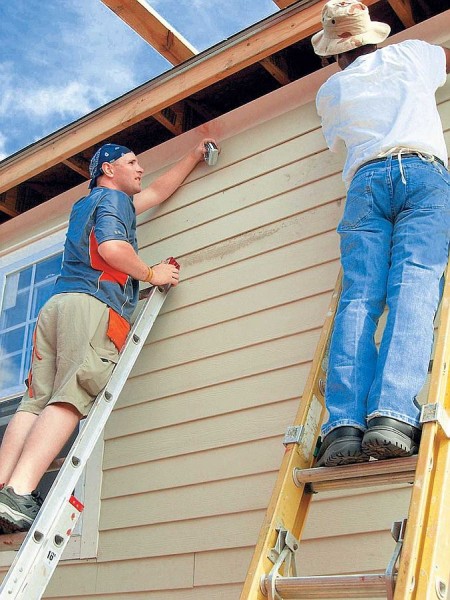 Installation of siding on the facade of a wooden house