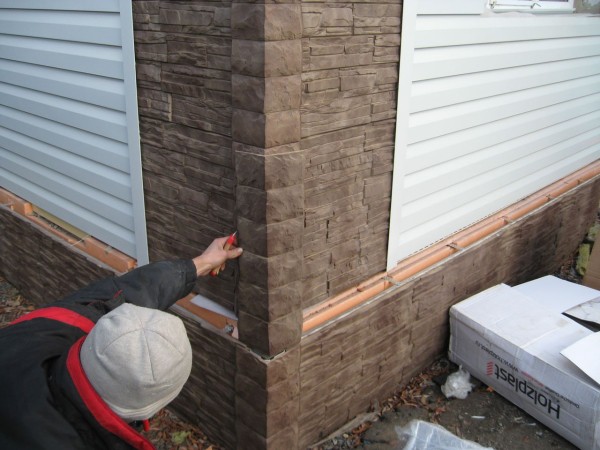 Finishing the foundation of the house and its walls: compact panels with imitation stone