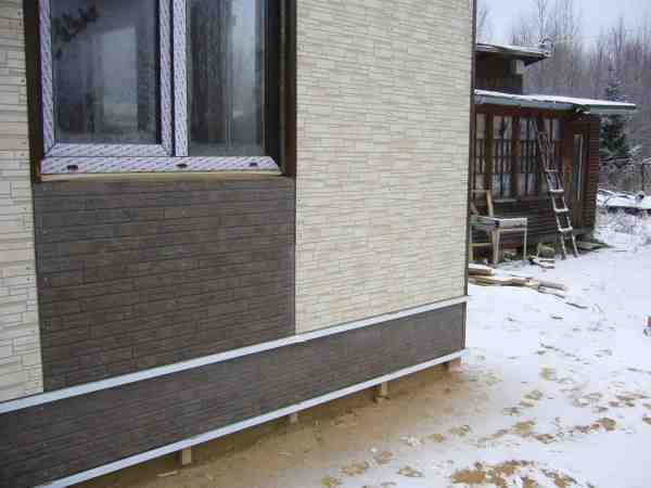 Finishing the base of the pile screw foundation with siding panels