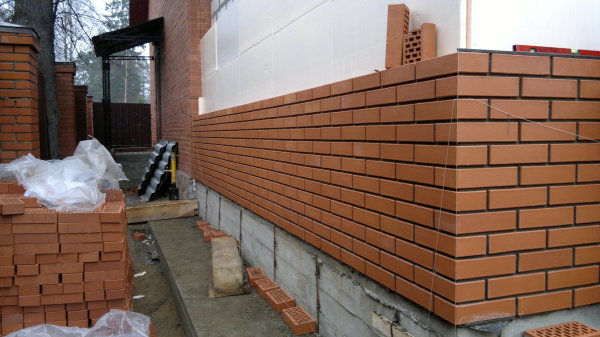 Leaning brick cladding on the protruding base