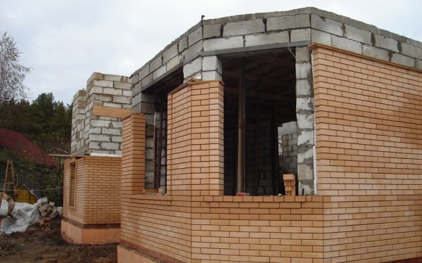 The construction of walls from gas blocks, with parallel brick lining