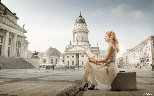 Girl with a book on the background of the city square