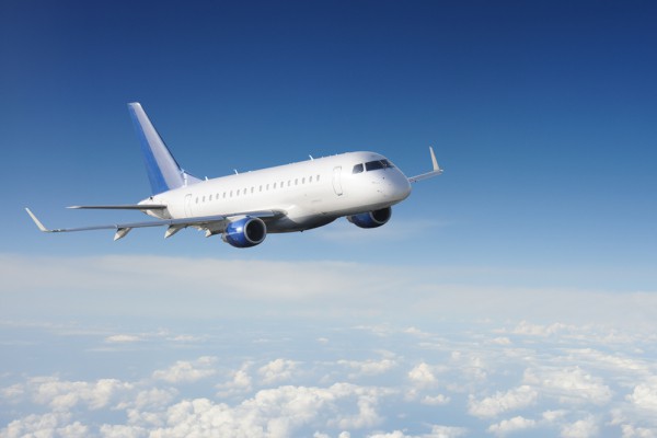 Wall mural with airplane hovering above the clouds