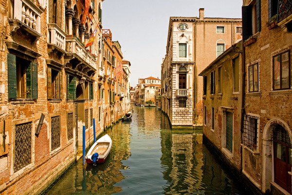 Wall mural with a narrow canal and houses standing along it