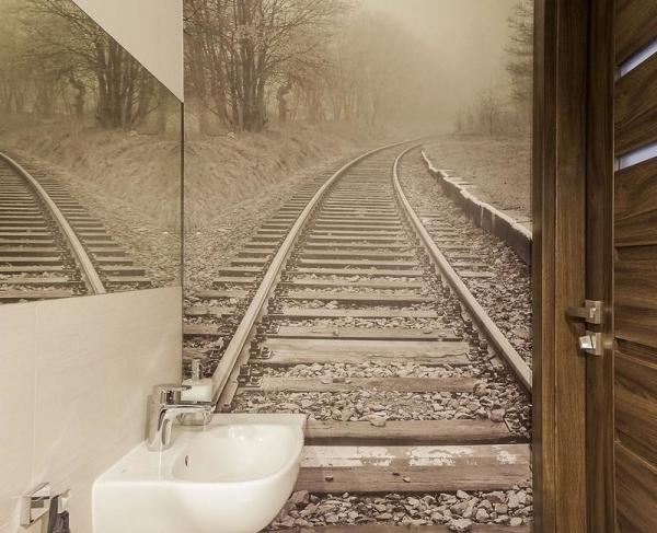 Wall mural on the wall of the toilet with the image of the railway will help to visually enlarge the room