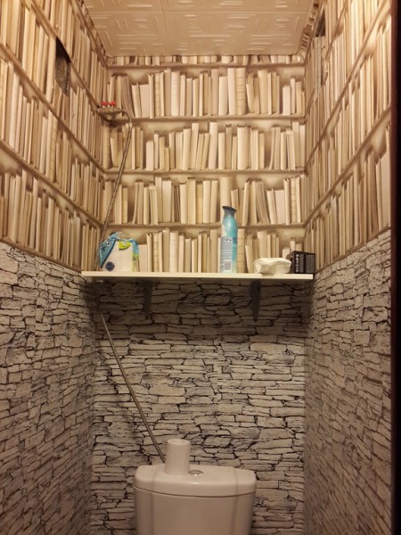 Wall mural with imitation of masonry and book shelves in the interior of the toilet