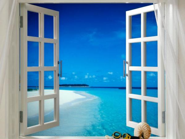 Wall mural with the image of a window with a view of the blue sky and transparent sea