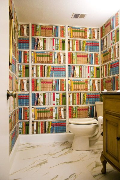 Wall mural with the image of shelves filled with books in the interior of the toilet