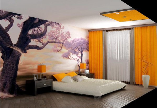 Wall mural in the bedroom over the bed, with the image of a blossoming sakura against the sunset, in the interior of the bedroom