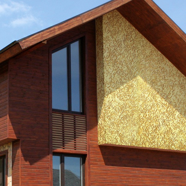 Photo of the facade decoration with decorative bark beetle plaster