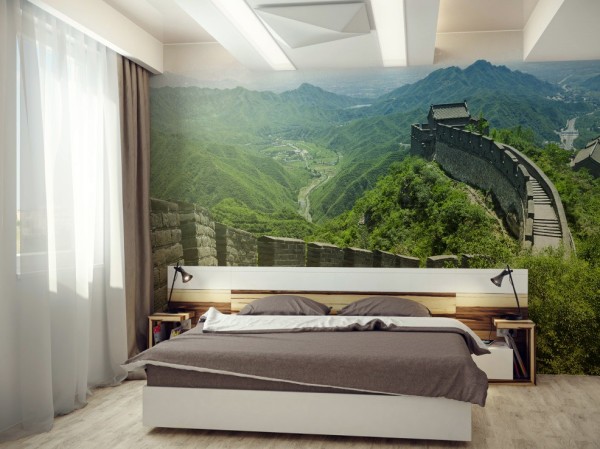 In the photo, an example of how photowall-paper with a beautiful and green mountain landscape looks in the bedroom, relaxing and calming its inhabitants before bedtime and energizing them in the morning