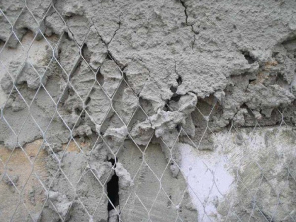 In the photo, the process of applying plaster on a metal reinforcing mesh