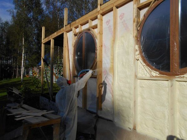 Application of liquid foam insulator on the wall of the house. Personal protective equipment is essential here.