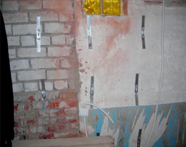 Wall prepared for decoration, with fixed guy wires for installation of metal guide profiles