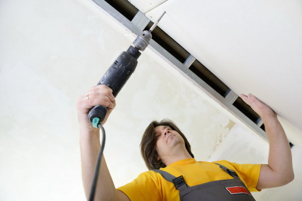 In the photo we see the process of installing drywall on the crate using self-tapping screws and a conventional do-it-yourself drill