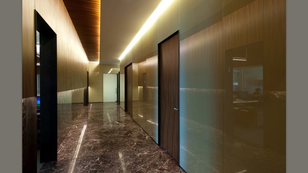 The photo shows an example of how to decorate the corridor walls with plastic panels, visually expanding the space with a glossy surface and backlight