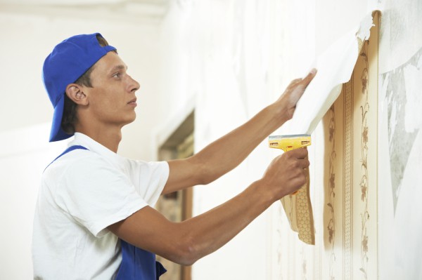 The photo shows the process of cleaning walls from old finishes, wallpapers that quite easily move away from the wall surface