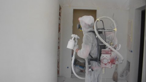 Wall painting process using a compressor on the shoulders