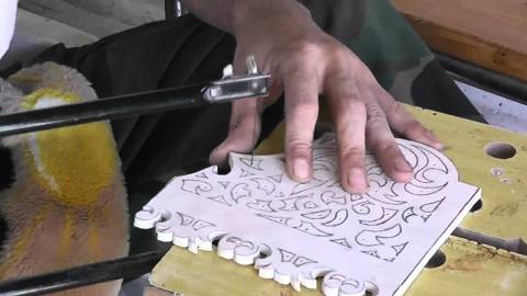 We see the process of creating a wooden panel with a jigsaw