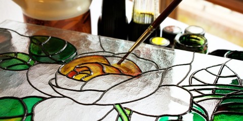 We see the process of creating a glass panel imitating antique stained-glass windows