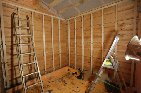 In the photo we see the preparation of the walls of a wooden house, with plasterboard lining