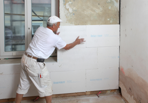 In the photo we see the process of warming the internal walls of the house with foam sheets