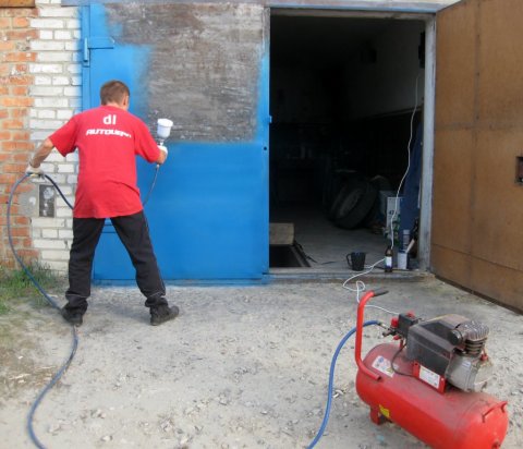 The process of painting a metal door with nitro paint using a spray gun