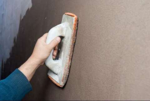 Grouting the wall with a metal grater