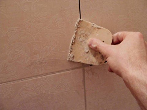 Grouting with a rubber spatula.