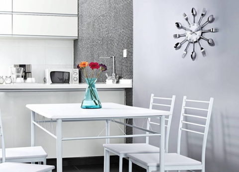 Metal clock on a plain kitchen wall