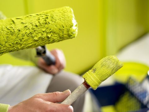 In the photo - painting tools: brush for corners and a roller for wall planes