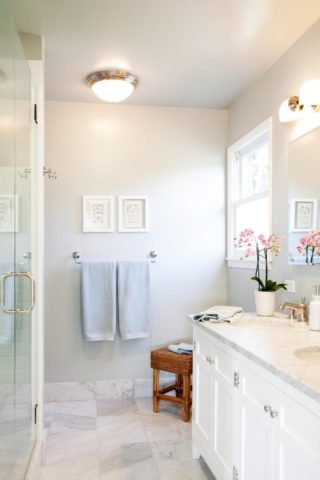 The photo clearly shows how spacious the white bathroom looks.