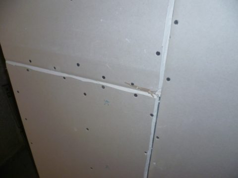 Seams between adjacent sheets of drywall