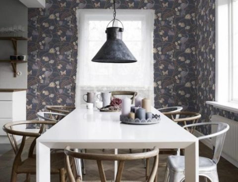 Dark non-woven wallpaper with a colorful pattern are the background for the snow-white plane of the table