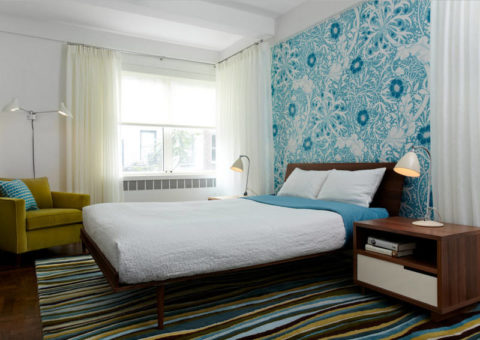 The color of the wallpaper resonates with textiles and carpet.